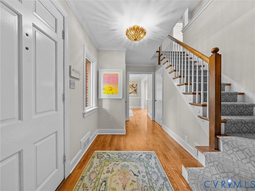 1113 E Durwood Crescent, Tuckahoe Area, Henrico, VA 23229 Hardwood flooring, crown molding, white paneled entry door, staircase with wood newel post and balusters, and a modern ceiling light fixture