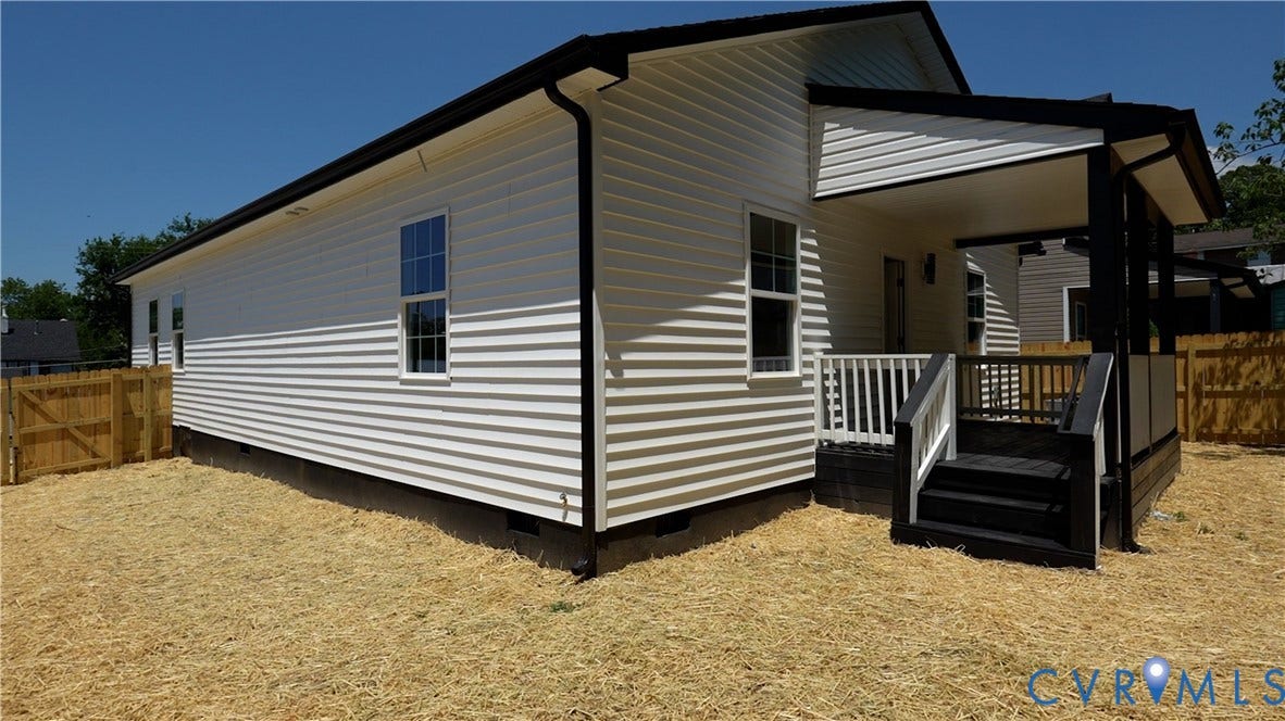 326 Mars Street, Petersburg, VA 23803 White horizontal siding exterior with contrasting black trim, covered porch, deck with white railings, and a wood fence