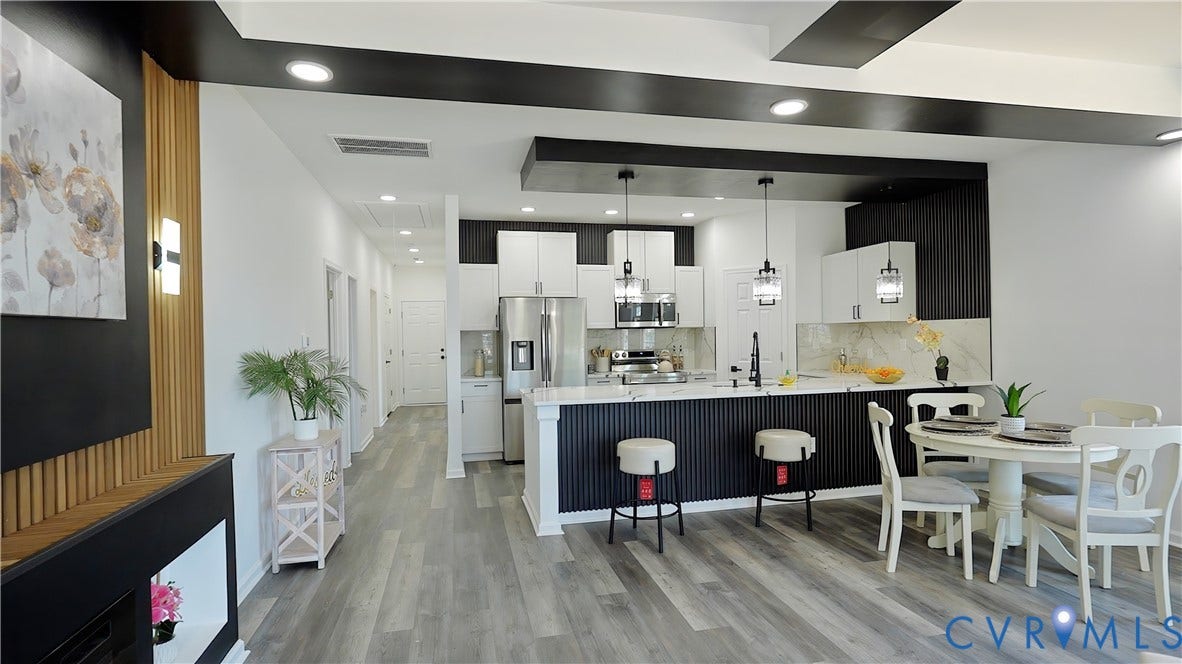 326 Mars Street, Petersburg, VA 23803 Modern kitchen with white cabinetry and stainless steel appliances, featuring a large island with pendant lighting and bar seating