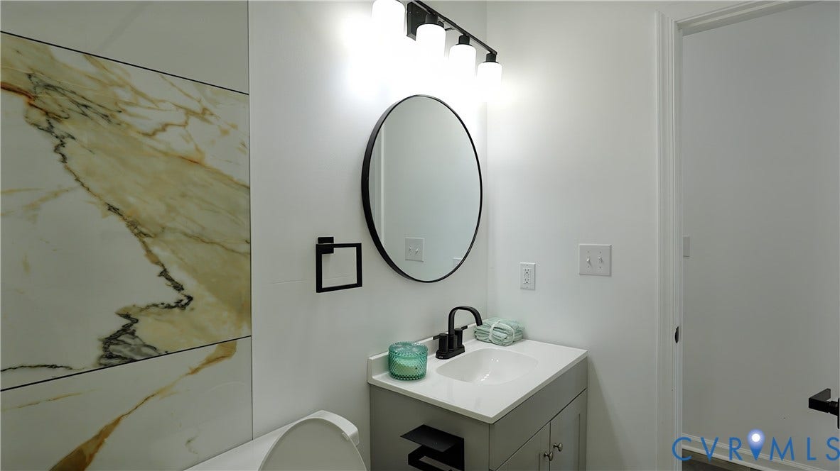 326 Mars Street, Petersburg, VA 23803 Vanity with integrated sink, sleek black faucet, and round mirror