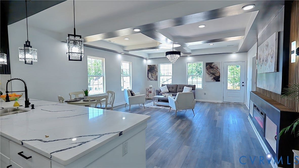 326 Mars Street, Petersburg, VA 23803 Open-concept living space with a kitchen island featuring a white countertop with dark veining, recessed lighting, wood-finish flooring, a tray ceiling, and an electric fireplace