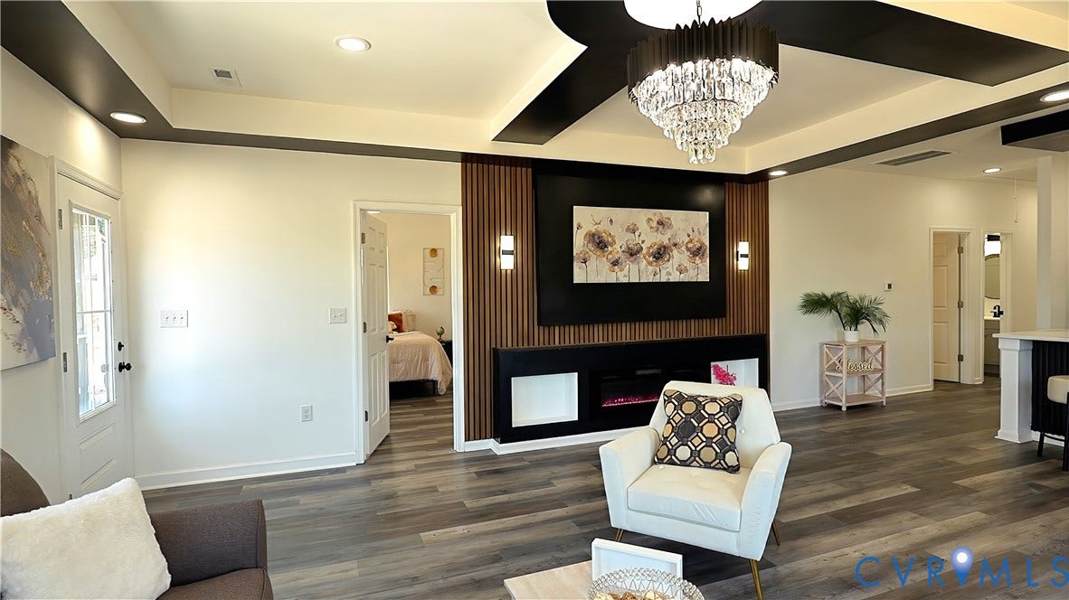 326 Mars Street, Petersburg, VA 23803 Recessed lighting, wood-finish flooring, accent wall with vertical wood paneling, built-in electric fireplace, and a tiered crystal chandelier