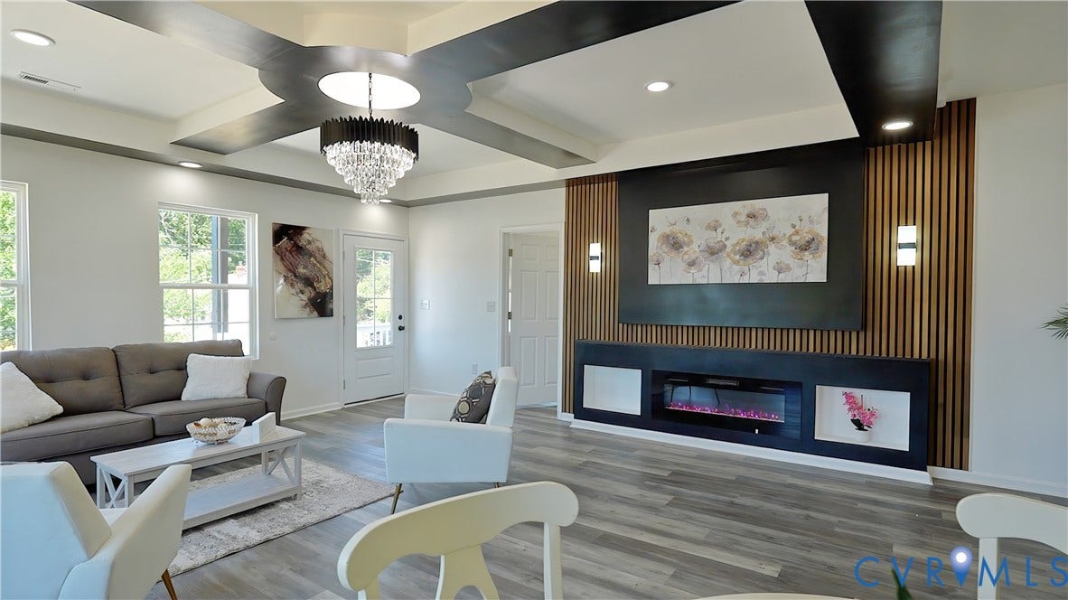 326 Mars Street, Petersburg, VA 23803 Tray ceiling with recessed lighting and a decorative chandelier, wood-finish flooring, and a built-in electric fireplace with display niches