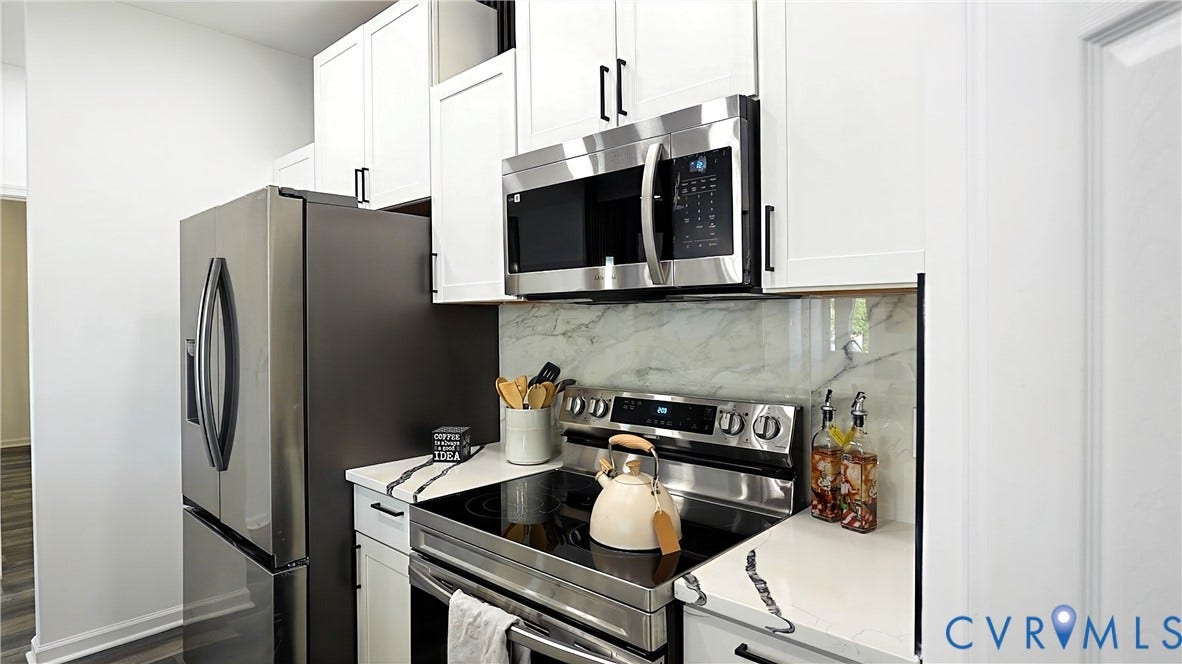 326 Mars Street, Petersburg, VA 23803 Stainless steel appliances, white cabinetry with dark hardware, stone-finish countertops, and a full-height backsplash