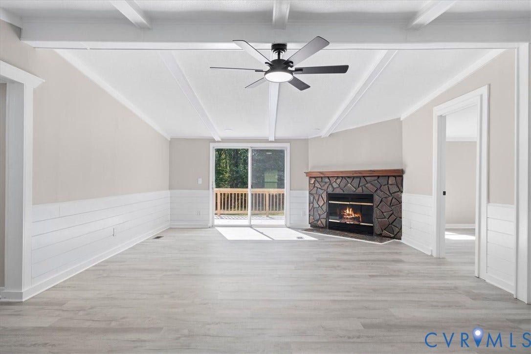 115 Mount Airy Lane, Cumberland, VA 23040 Vaulted ceiling with exposed beams, wood-finish flooring, stone fireplace with a wood mantle, shiplap wainscoting, and a ceiling fan with integrated lighting