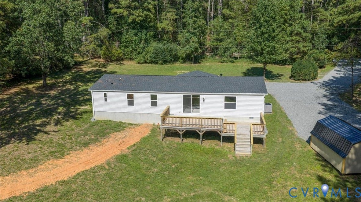 115 Mount Airy Lane, Cumberland, VA 23040 White siding exterior with a dark shingle roof, complemented by an expansive wooden deck featuring stairs and railings