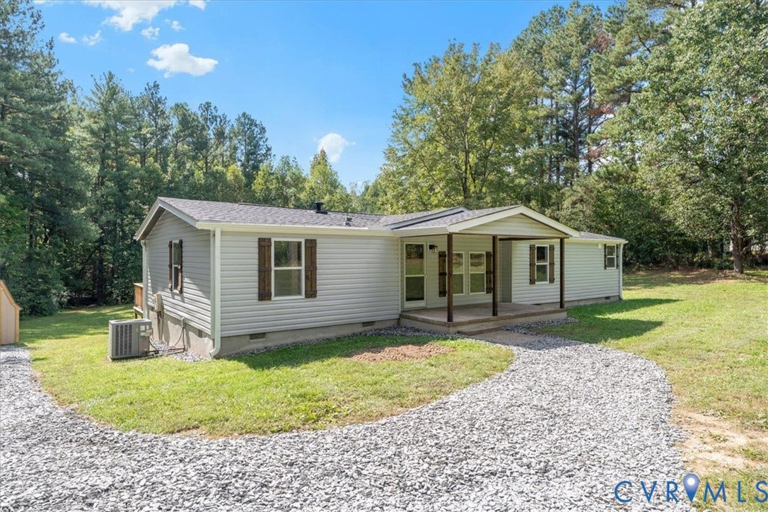 115 Mount Airy Lane, Cumberland, VA 23040 Light-colored siding exterior with dark wood-finish shutters, covered porch entry, gravel driveway, and a detached storage shed