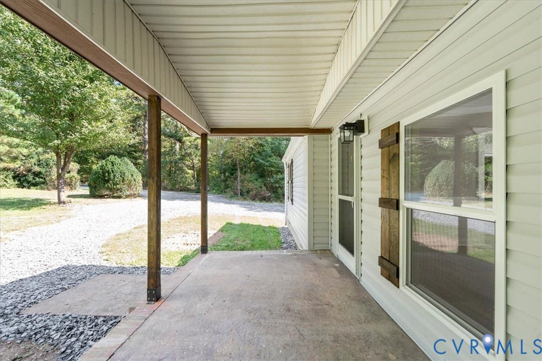 115 Mount Airy Lane, Cumberland, VA 23040 Covered concrete porch with white vinyl siding, decorative wood shutters, and an exterior light fixture