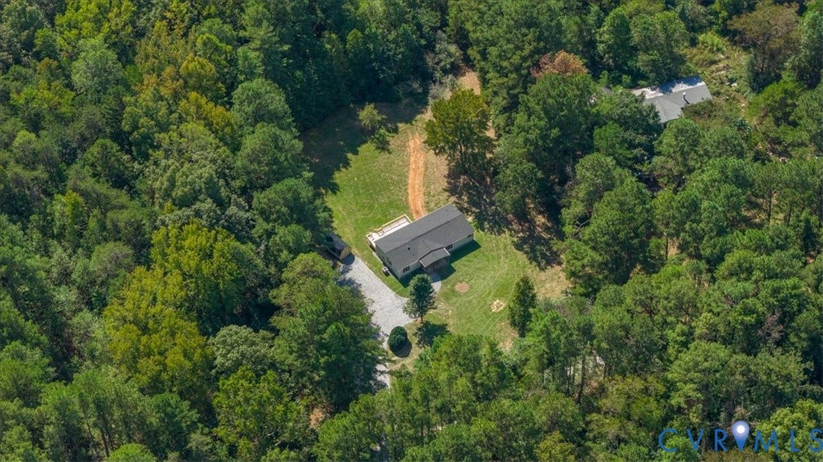115 Mount Airy Lane, Cumberland, VA 23040 Residential structure with a dark-pitched roof, surrounded by mature trees, featuring a light-toned gravel driveway
