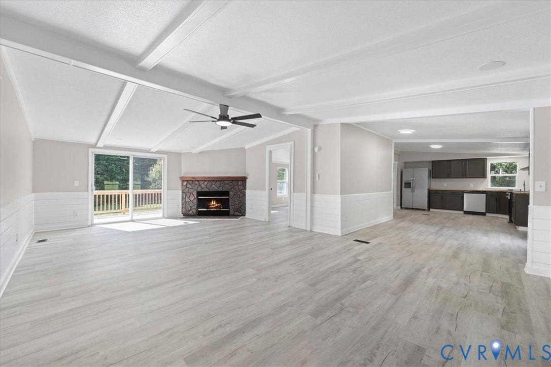 115 Mount Airy Lane, Cumberland, VA 23040 Spacious room with light wood-finish flooring, a stone-surround fireplace, and a ceiling fan