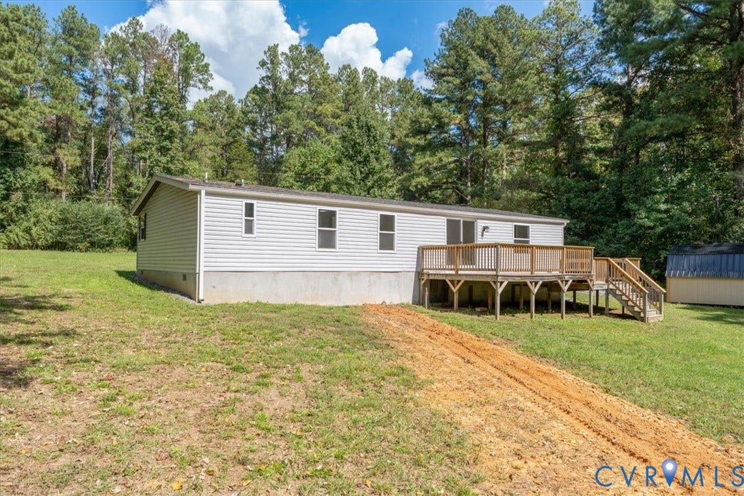 115 Mount Airy Lane, Cumberland, VA 23040 Expansive rear yard with a wood deck, wood-tone railing, and integrated stairs