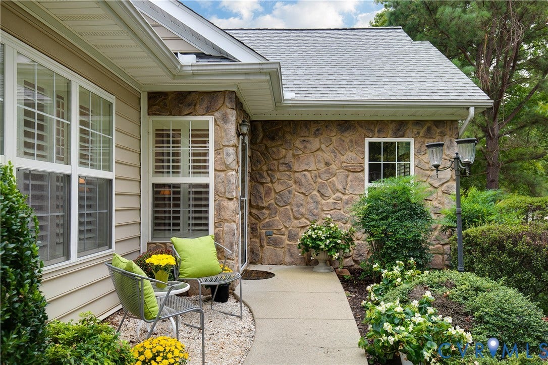 Stone facade accenting the entry, with siding and white-framed windows