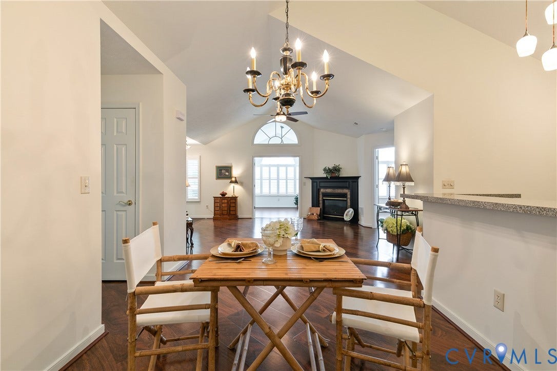 Vaulted ceilings, wood-finish flooring, and a fireplace with a mantel