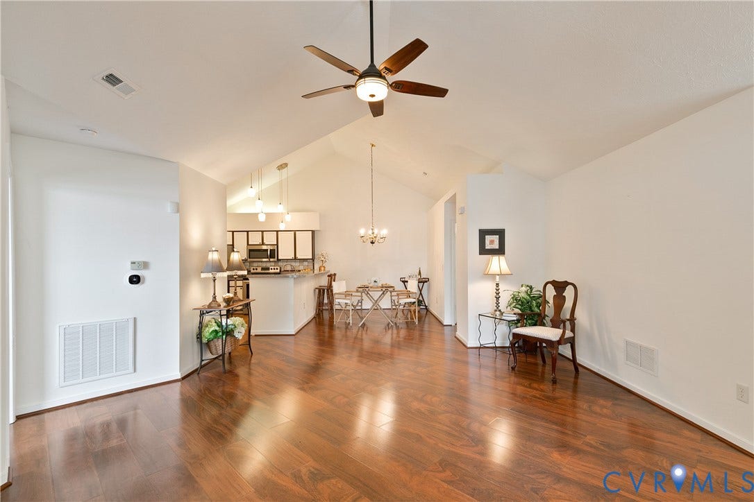 Hardwood-finish flooring, vaulted ceilings, contemporary ceiling fan, recessed lighting, and a breakfast bar with pendant lighting