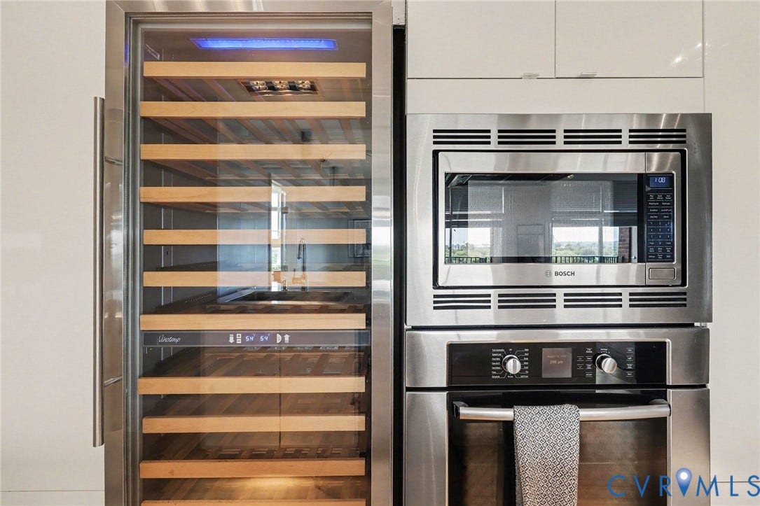 1101 Haxall Point, #U512 U510, Richmond, VA 23219 Built-in stainless steel oven and microwave combination, integrated stainless steel wine refrigerator with glass paneling, and wood-finish shelving