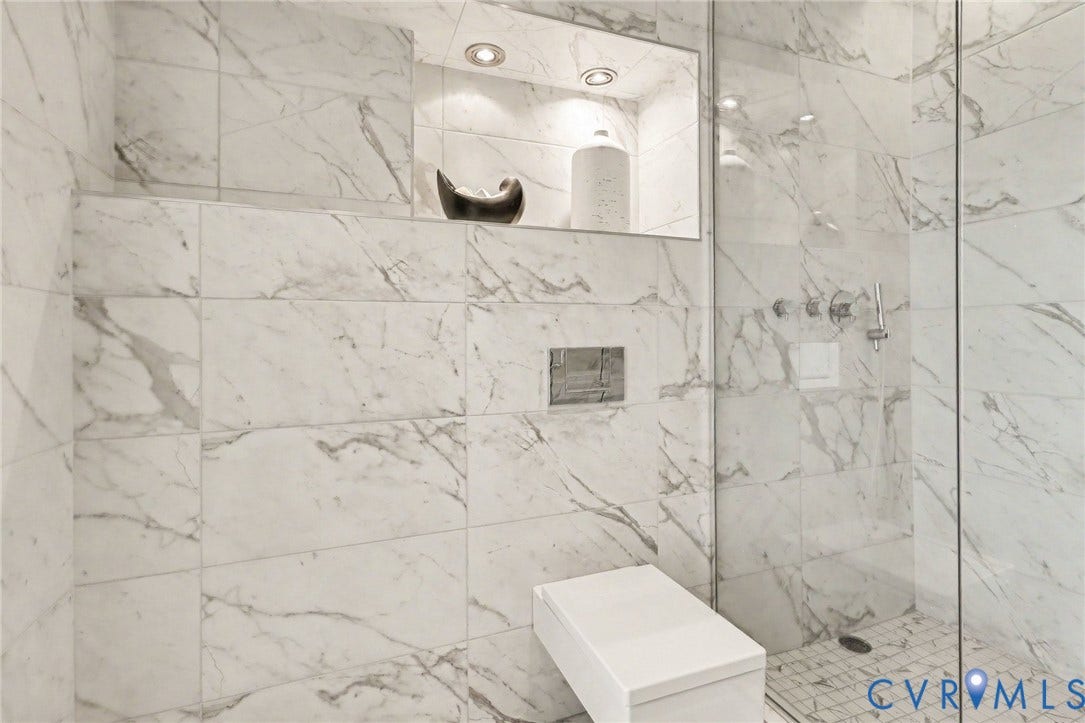 1101 Haxall Point, #U512 U510, Richmond, VA 23219 Shower featuring floor-to-ceiling white marble-look tile, glass enclosure, built-in recessed shelf with integrated lighting, and a built-in shower bench