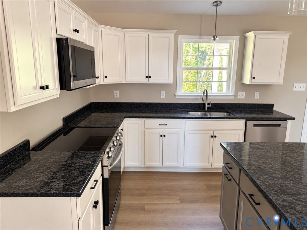 7735 Jefferson Highway, Cedar Hill Park, Mineral, VA 23117 Kitchen featuring white cabinetry, dark speckled countertops, stainless steel appliances, wood-finish flooring, and a single basin sink with a gooseneck faucet