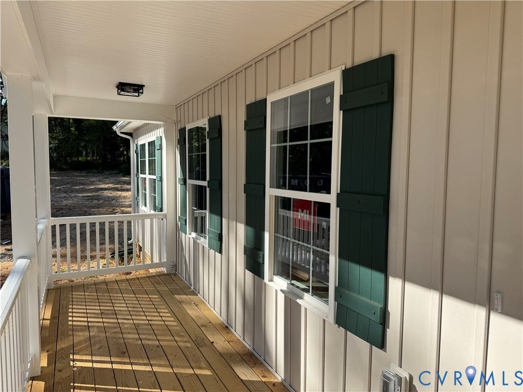 7735 Jefferson Highway, Cedar Hill Park, Mineral, VA 23117 Covered porch featuring wood flooring, white railing, board and batten siding, and dark green shutters