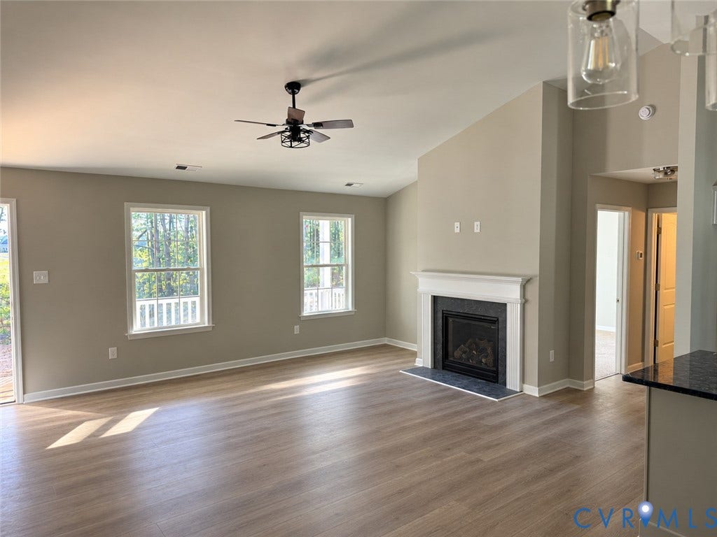 7735 Jefferson Highway, Cedar Hill Park, Mineral, VA 23117 Vaulted ceilings, wood-finish flooring, a fireplace with a white mantel and dark hearth, a ceiling fan, and recessed lighting