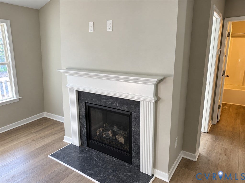 7735 Jefferson Highway, Cedar Hill Park, Mineral, VA 23117 Gas fireplace with a dark stone surround and hearth, white mantel, and wood-finish flooring