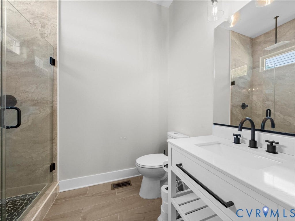 Vanity with integrated sink, matte black faucet, and open shelving
