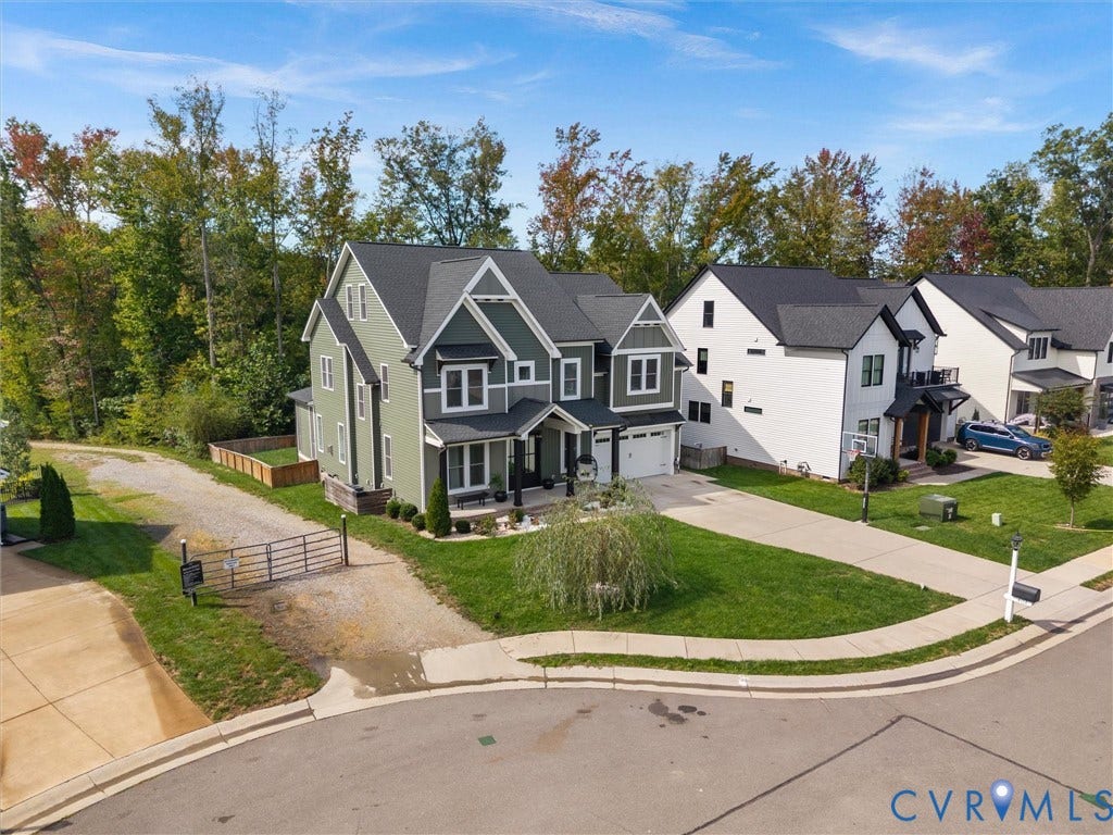 Two-story residence featuring a gabled roofline and light green siding with dark green accents