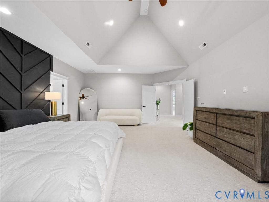 Vaulted ceiling with recessed lighting, black accent wall paneling, light-colored carpeting, and double doors