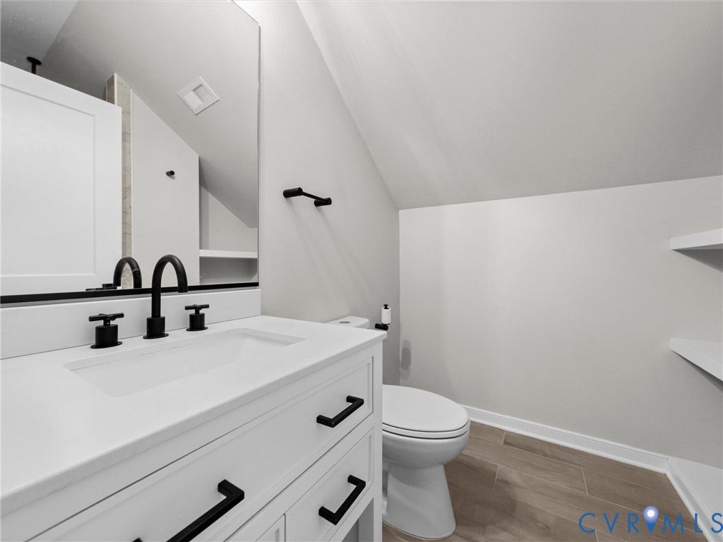 White vanity with integrated rectangular sink and matte black hardware