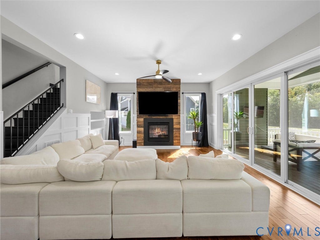 Open-concept living area featuring a four-section modular sectional sofa, wide-plank wood-finish flooring, recessed ceiling lighting, and a ceiling fan