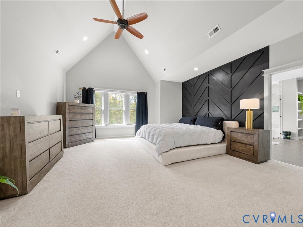 Vaulted ceiling with a ceiling fan, recessed lighting, expansive windows, patterned accent wall, and plush carpeting