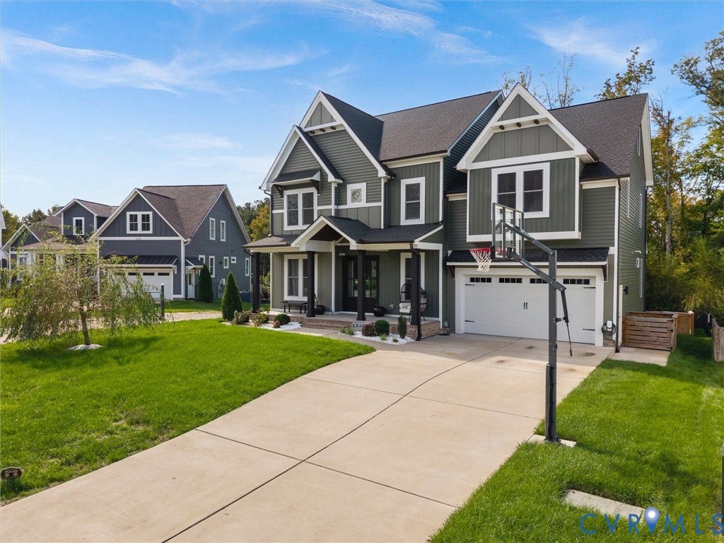 Craftsman-style exterior with board and batten siding, multiple gables, covered entry porch, dark shingle roofing, and an attached two-car garage