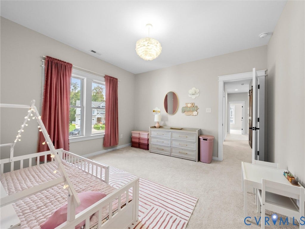 Bright, light-filled bedroom featuring expansive windows with red curtains, neutral wall finishes, and recessed ceiling lighting