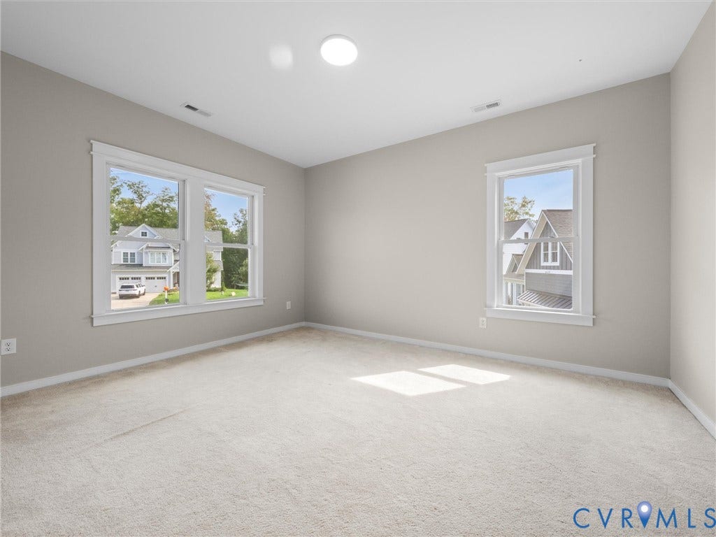 Recessed lighting, light-toned carpeting, multiple windows, and neutral wall tones
