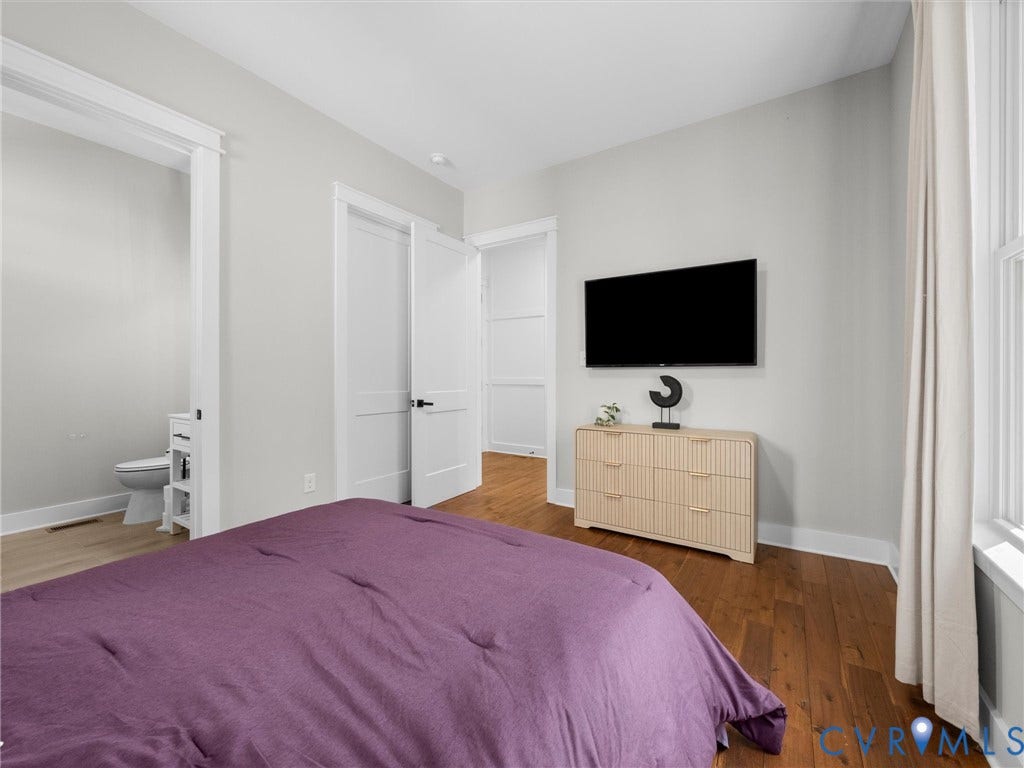 Hardwood flooring, white trim, recessed lighting, white interior doors, and a window with natural light