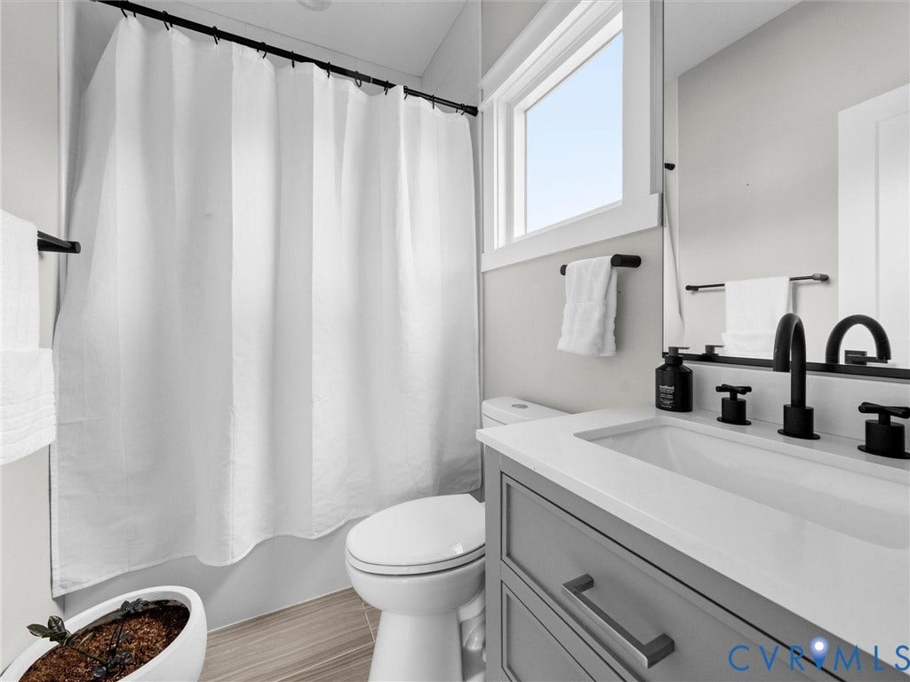 White vanity with a rectangular undermount sink, black-finish faucet, and coordinating cabinet hardware