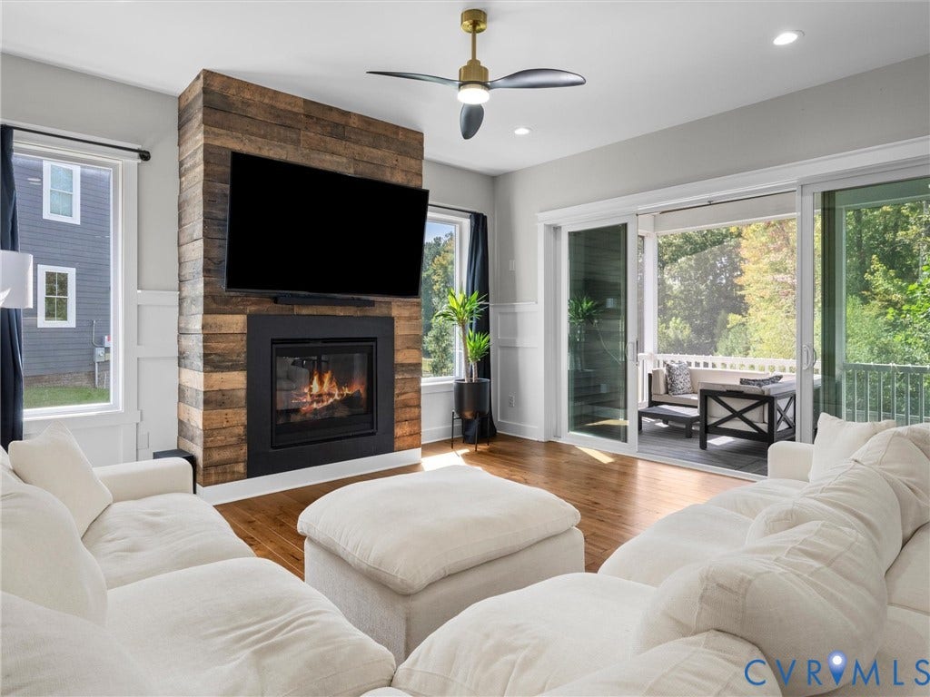 Living area featuring a reclaimed wood-finish fireplace surround, recessed lighting, and wood-finish flooring