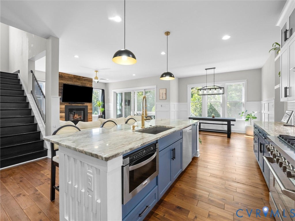 Spacious kitchen with a large island featuring stone countertops and integrated microwave