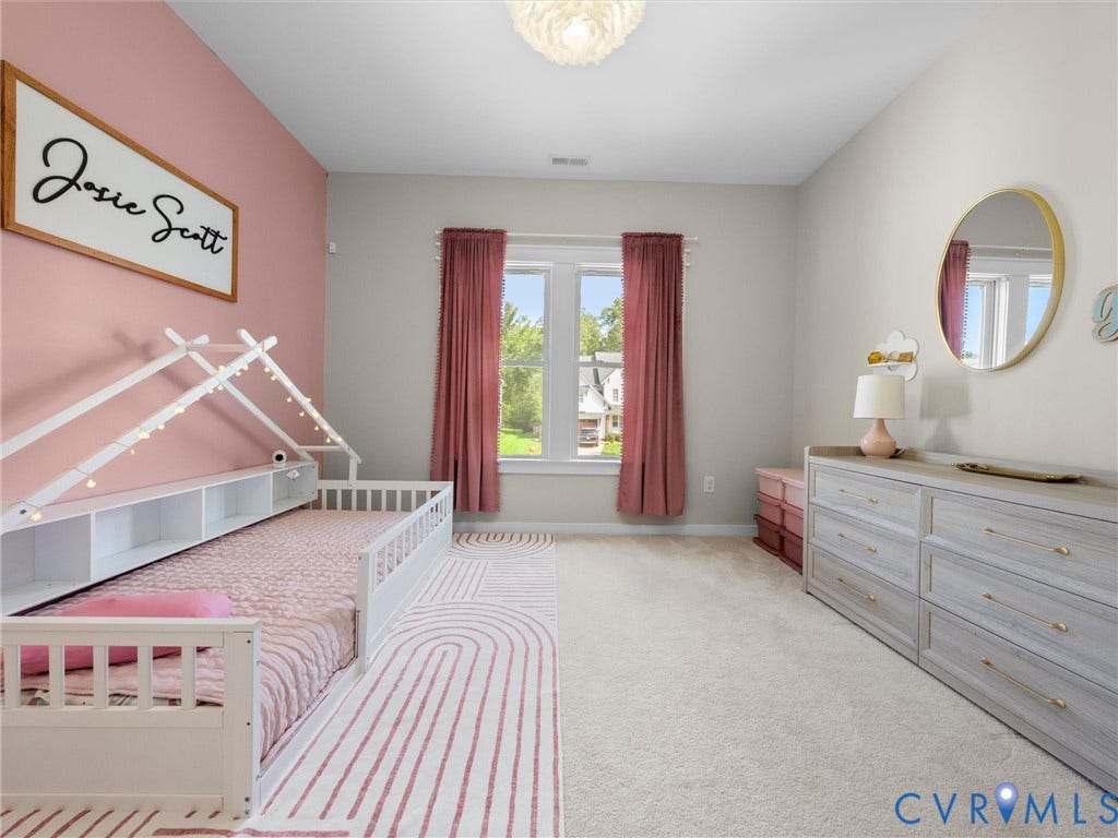 Carpeted flooring, window with natural light, built-in shelving, light fixture, and a dresser with brass hardware