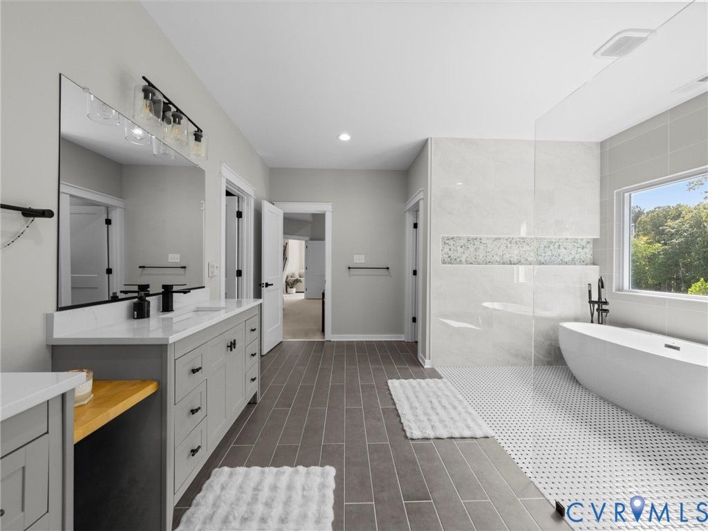 Dual vanity with matte black fixtures, quartz countertop, and extensive storage