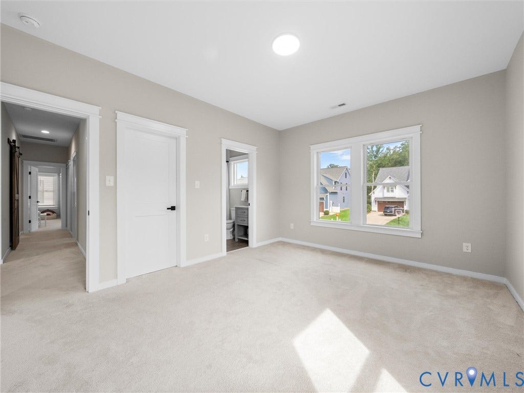 Recessed ceiling lighting, light-toned wall paint, white trim, carpet flooring, and a double window