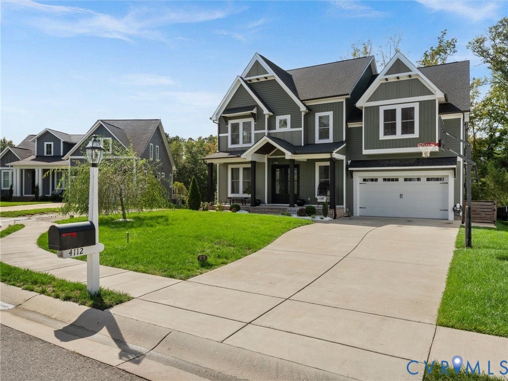 Two-story home with a two-car garage, concrete driveway, and manicured front lawn