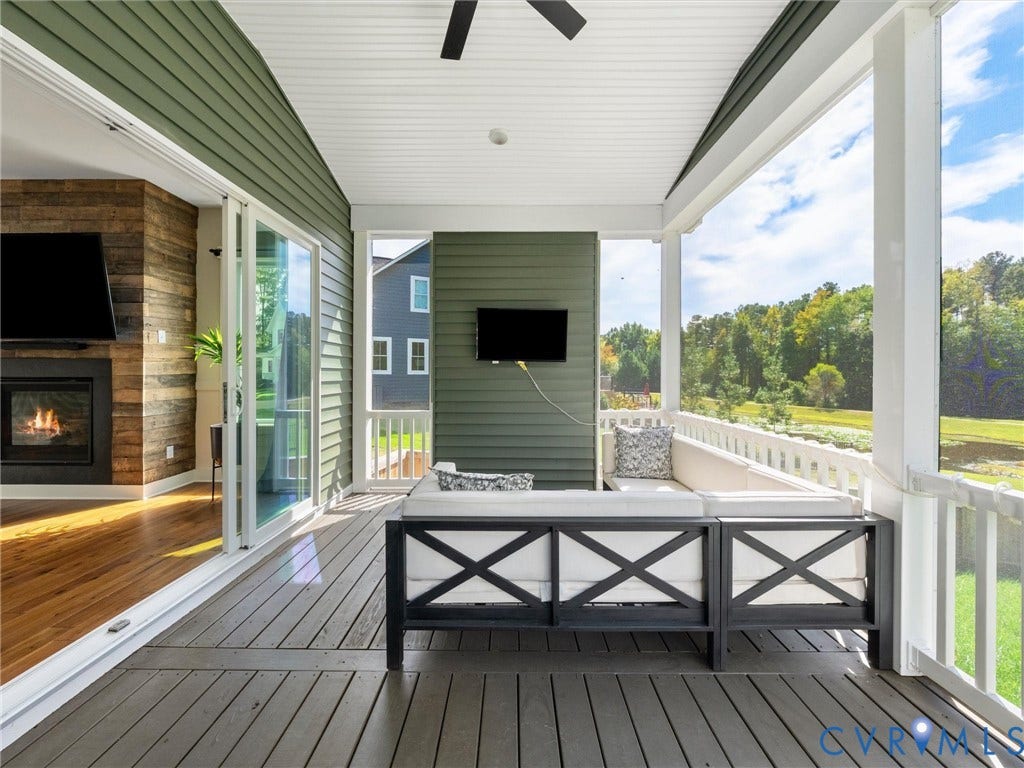 Screened porch featuring a ceiling fan, white beadboard ceiling, and composite decking