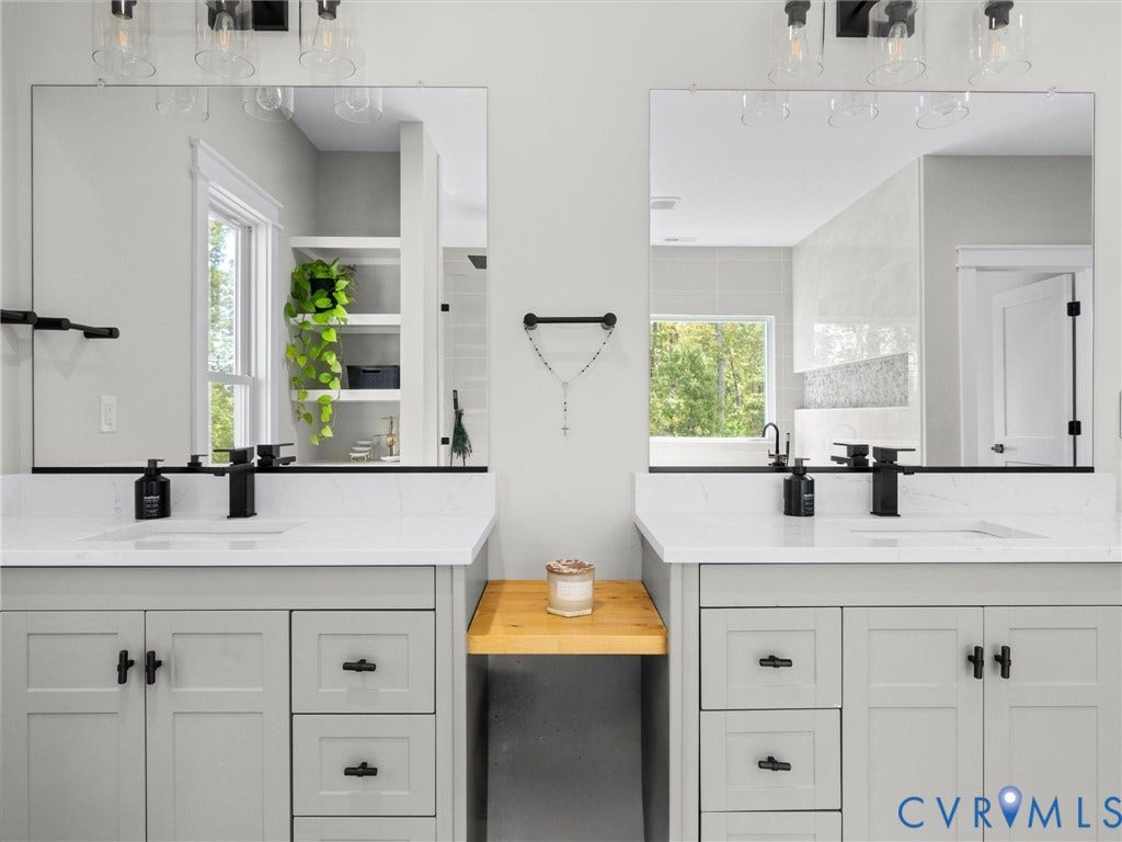 Double vanity featuring light gray cabinetry, white countertops, integrated sinks, and matte black fixtures