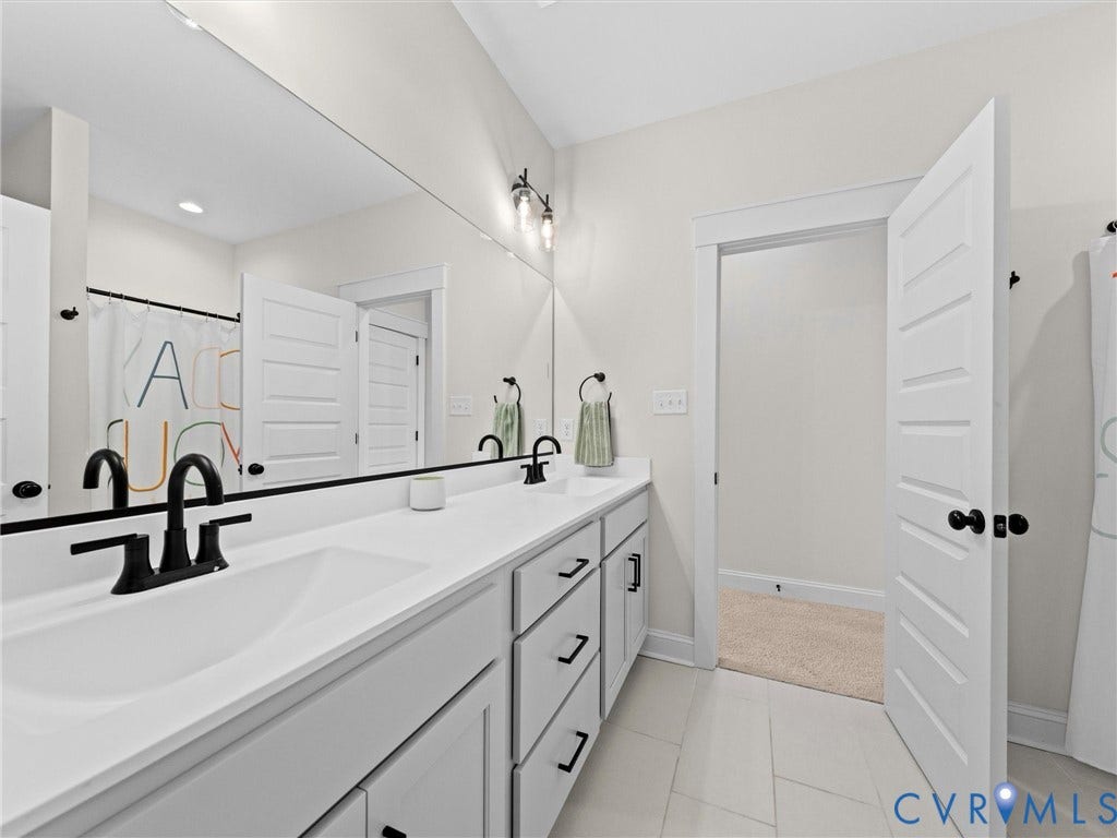 3719 Bellstone Drive, Midlothian, VA 23112 Expansive vanity with dual integrated sinks, white countertops, black matte fixtures, and a full-width mirror