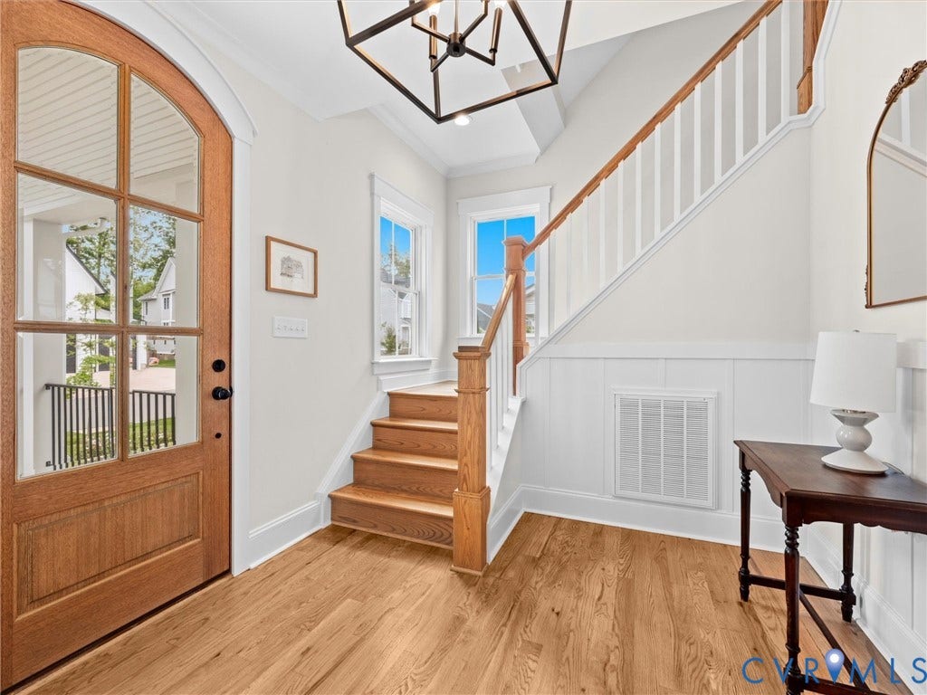 3719 Bellstone Drive, Midlothian, VA 23112 Wood-finish flooring throughout the entry, staircase with a wood handrail, and white paneling