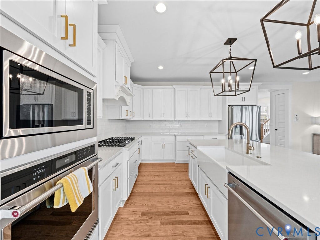 3719 Bellstone Drive, Midlothian, VA 23112 White cabinetry with gold-tone hardware, stainless steel appliances, wood-finish flooring, white subway tile backsplash, and geometric pendant lighting