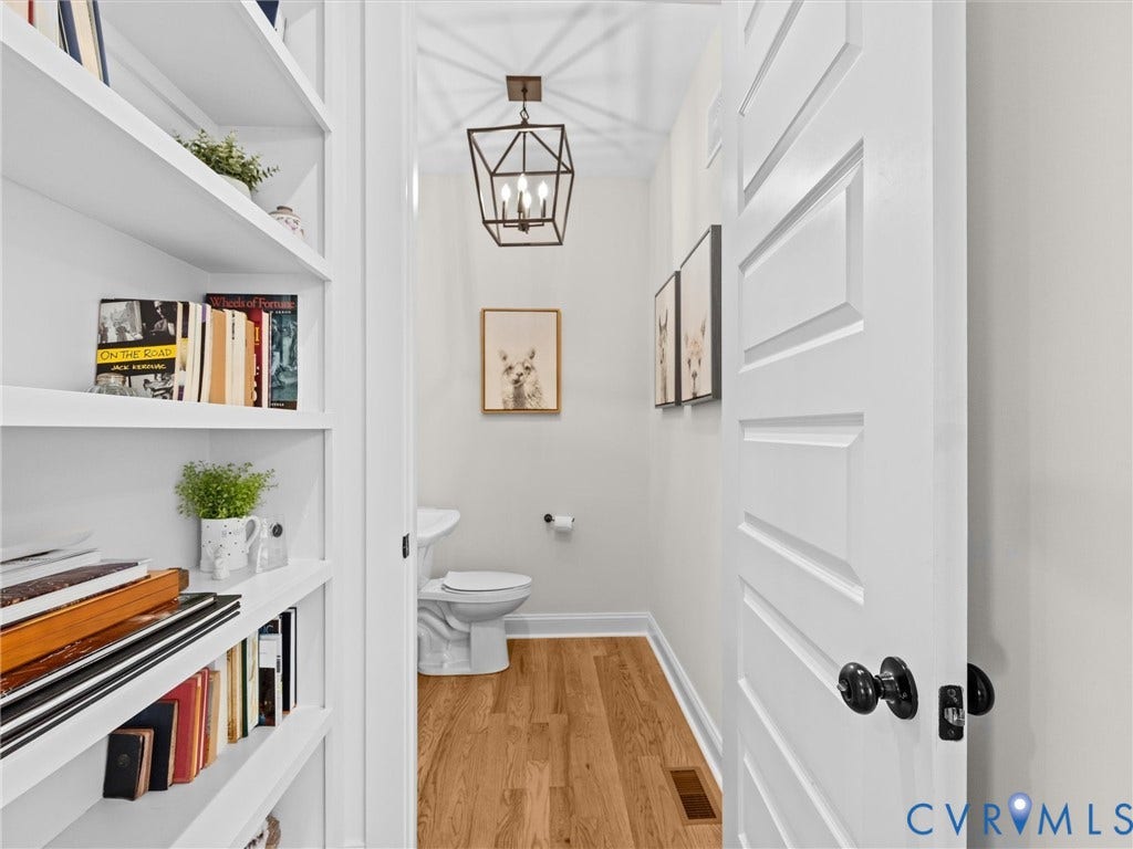 3719 Bellstone Drive, Midlothian, VA 23112 Built-in shelving, wood-finish flooring, white paneled door with black hardware, and a geometric light fixture