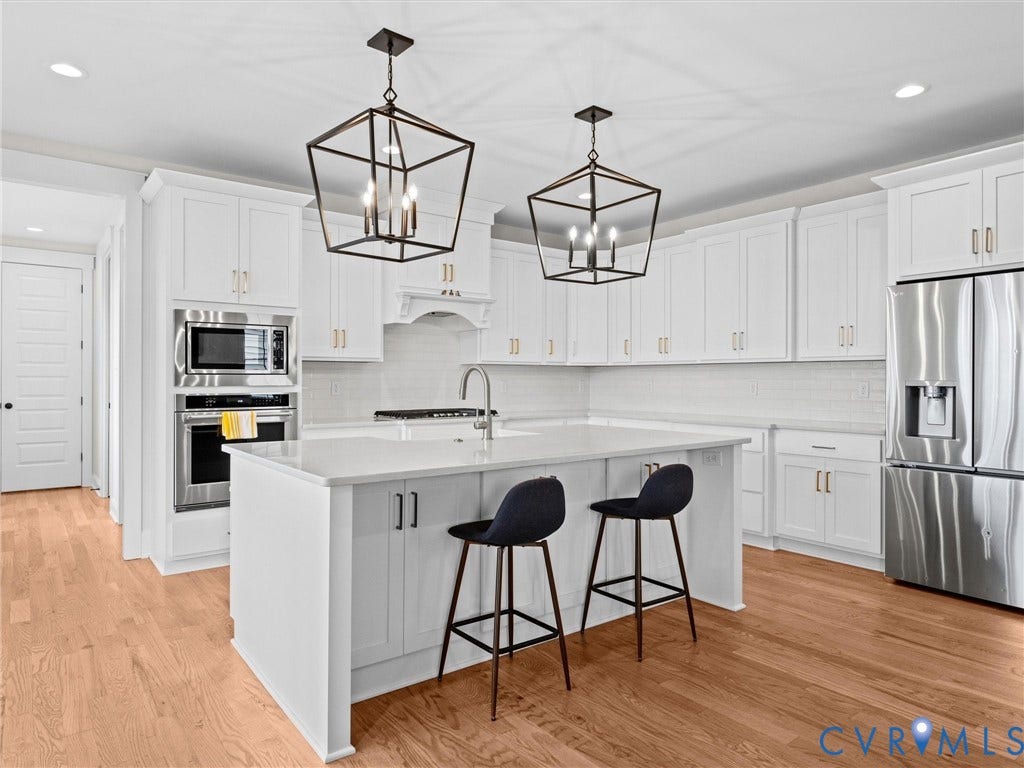 3719 Bellstone Drive, Midlothian, VA 23112 Kitchen featuring white cabinetry, stainless steel appliances, a center island with countertop seating, and light wood-finish flooring