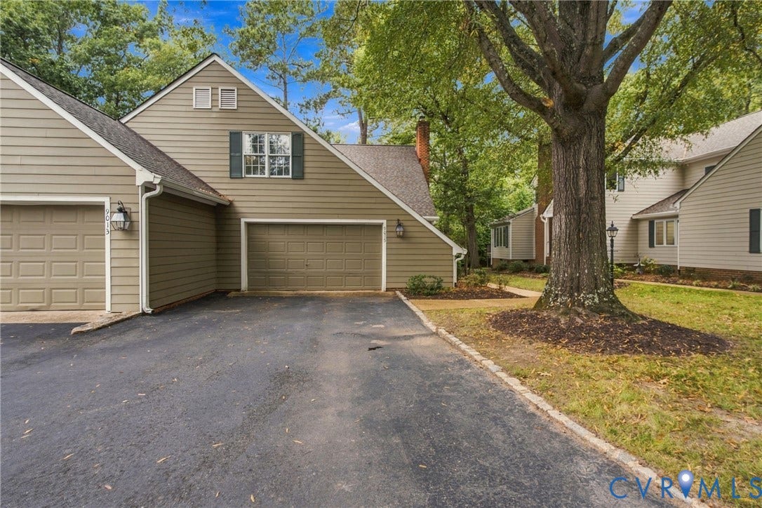 9015 Wood Sorrel Drive, Henrico, VA 23229 Horizontal lap siding exterior, asphalt driveway, dual garage doors, and mature trees
