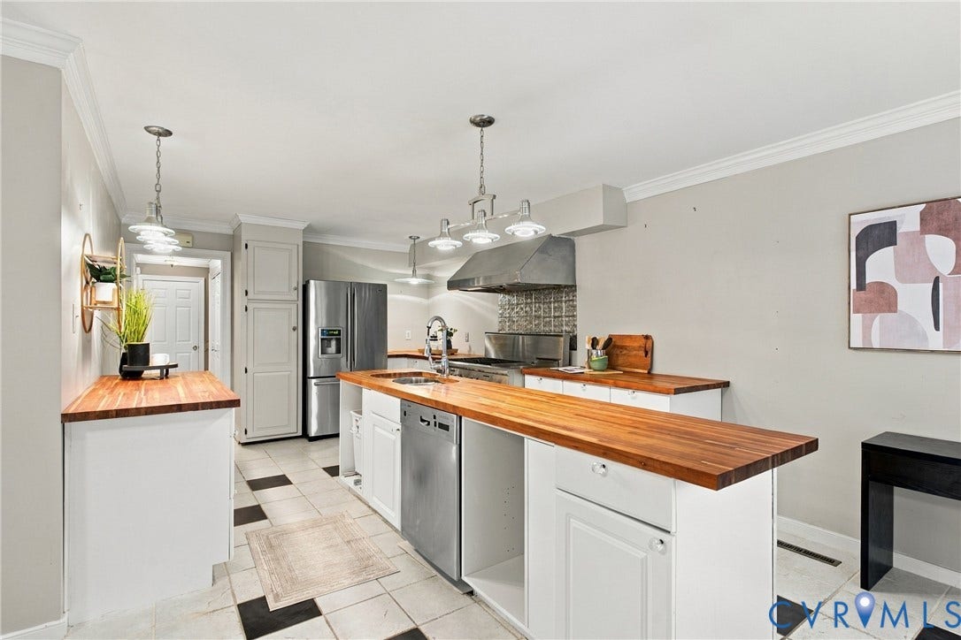 9015 Wood Sorrel Drive, Henrico, VA 23229 Chef's kitchen featuring white cabinetry with wood-finish countertops, stainless steel appliances including a gas range and refrigerator, pendant lighting over the island, and ceramic tile flooring throughout the open layout